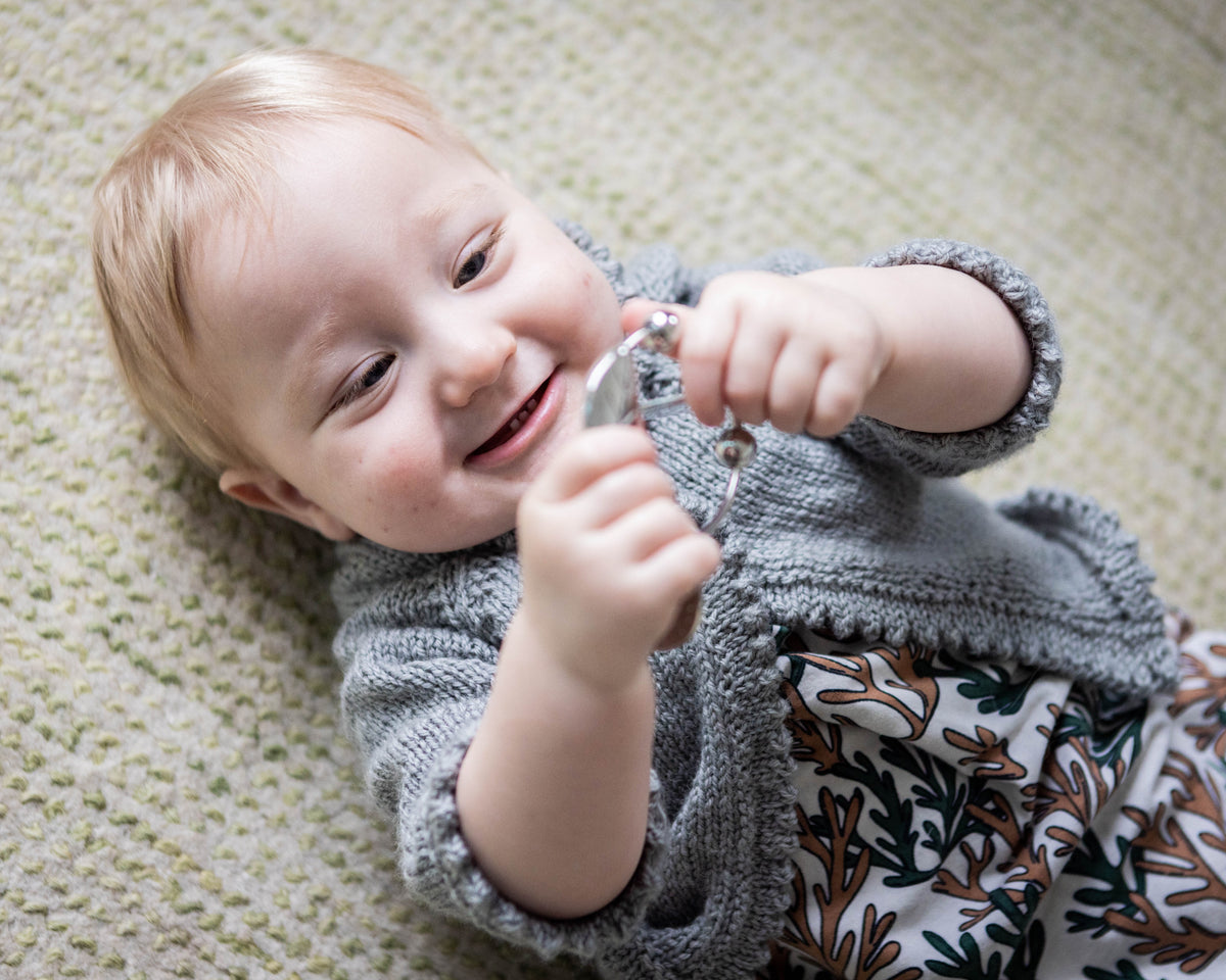 baby lying on floor smiling at yummikeys